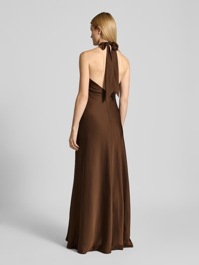 Frauenmodel trägt Abendkleid mit Neckholder zum Binden von Mascara aus braunem Satin mit Rückenausschnitt und Maxilänge, Ganzkörperansicht Rückansicht. Körpernahe Passform, Nahtreißverschluss, Rückenlänge bei Größe 36: 160 cm, Brustweite bei Größe 36: 42 cm.