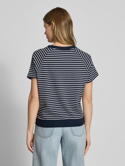 Vrouwenmodel draagt Relaxed Fit T-Shirt aus Baumwoll-Mix mit Label-Patch van G-Star Raw, donkerblauw-wit gestreept, elastische zoom, korte mouwen, raglanmouwen, damesshirt, katoen-elastaan mix, ronde hals, ruglengte maat S 57 cm, volledige lichaamsweergave achterkant.