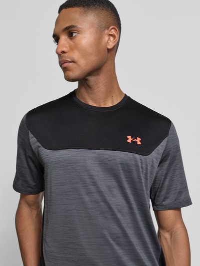Męski model ma na sobie Regular Fit T-Shirt mit Logo-Print Modell 'Utility' von Under Armour, elastyczna mieszanka materiałów, okrągły dekolt, krój regular fit, nadruk z logo, długość tyłu w rozmiarze M: 62 cm, przód, zbliżenie na górną część ciała.