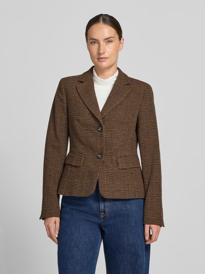 Kobieta modelka nosi żakiet Blazer mit Reverskragen und Pattentaschen od White Label, mieszanka materiałów z dodatkiem wełny lana, taliowany krój, kołnierz z połami, listwa guzikowa, kieszenie z patką, długość tyłu w rozmiarze 36: 57 cm, szerokość w rozmiarze 36: 45 cm, długość rękawów w rozmiarze 36: 63 cm, widok całej sylwetki od przodu.