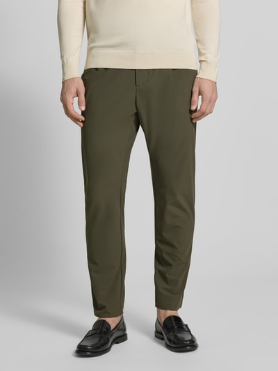 Mężczyzna nosi Slim Fit Hose mit Paspeltaschen am Gesäß od CRUNA, materiał elastyczny, kolor oliwkowy, krój slim fit, Szerokość w rozmiarze 50: 44 cm, długość nogawki wewnętrzna: 73 cm, widok całej sylwetki z przodu.