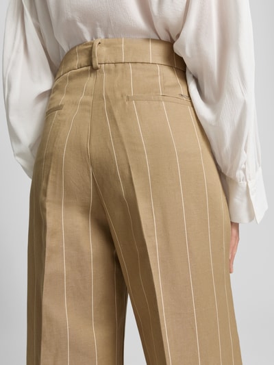 Männermodel trägt Wide Leg Hose aus Baumwoll-Leinen-Mix Modell 'MARLENE' von Brax mit Allover-Muster, gestreiftem Design und Label Patch, Detailaufnahme Rückansicht.