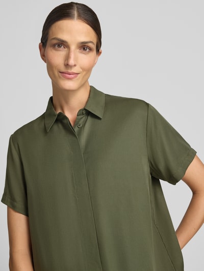 Frauenmodel trägt Relaxed Fit Bluse aus reinem Lyocell Modell 'Mina' von Samsøe Samsøe in Olivgrün, Kurzarm, Hemdblusenkragen, Nahaufnahme Oberkörper.