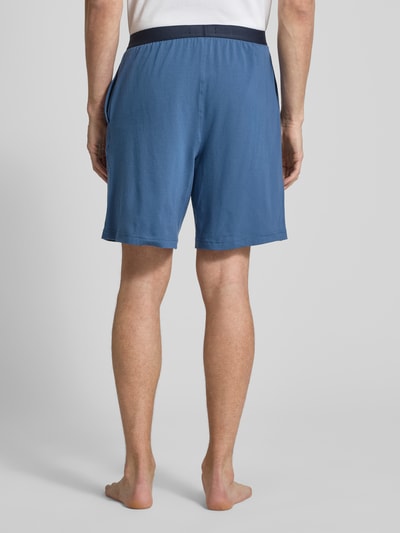 Männermodel trägt Regular Fit Sweatshorts aus Baumwoll-Mix von Tommy Hilfiger in Blau mit elastischem Bund, Jersey Sweat, Ganzkörperansicht Rückansicht.