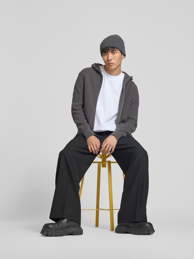 Männermodel trägt Regular Fit Jacke in Strick-Optik von WON HUNDRED aus reiner Baumwolle mit Kapuze und Zweiwege-Reißverschluss, Ganzkörperansicht von vorne.