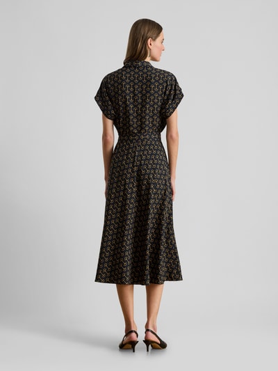 Frauenmodel trägt Tailliertes Wickelkleid aus Chiffon von Lauren Ralph Lauren mit Allover-Muster in Schwarz und Beige, Midi-Länge, taillierter Passform, V-Ausschnitt, Taillengürtel, kurzen Ärmeln mit fixiertem Umschlag, fließender Chiffon-Struktur, Ganzkörperansicht Rückansicht.