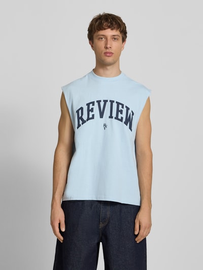 Männermodel trägt Tanktop mit Logo-Print von REVIEW in Hellblau, Reine Baumwolle, Gerader-Schnitt, Rundhalsausschnitt, Ganzkörperansicht von vorne. Rückenlänge bei Größe M: 68 cm.