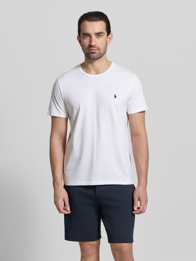 Männermodel trägt T-Shirt mit Logo-Stitching von Polo Ralph Lauren in Weiß, reine Baumwolle, gerade Passform, Rundhalsausschnitt, Ganzkörperansicht von vorne.