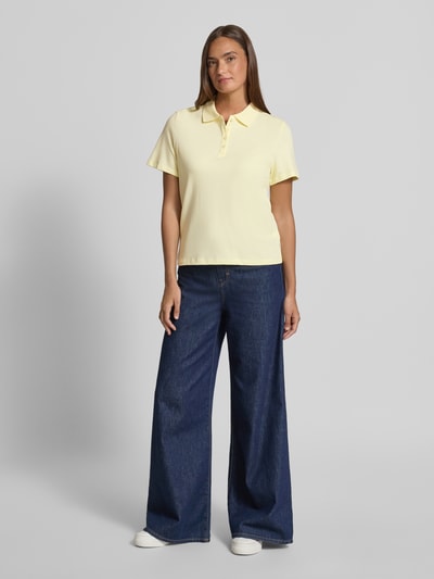 Frauenmodel trägt Regular Fit Poloshirt aus Baumwoll-Mix von s.Oliver RED LABEL in Gelb, unifarben, Piqué-Struktur, Ganzkörperansicht von vorne.