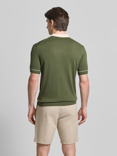 Męski model nosi Slim Fit Poloshirt mit Logo-Stitching von Gant, bawełna-modal, krój slim fit, zielony, kremowy kołnierzyk, widok całej sylwetki z tyłu.
