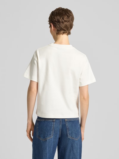 Frauenmodel trägt Boxy Fit T-Shirt aus reiner Baumwolle von Tommy Hilfiger in Optik: Unifarben, Passform: Boxy-Fit, Logo-Stitching, Rundhals, Ärmelform: Kurzarm, Materialverarbeitung: Interlock, Material: Reine Baumwolle, Ganzkörperansicht Rückansicht.
