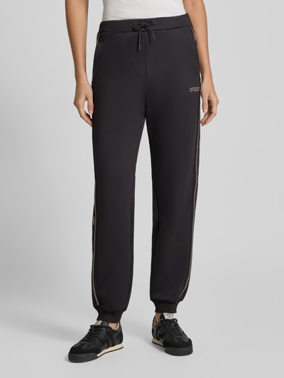 Frauenmodel trägt Sweatpants mit Label-Detail Modell 'OCTAVIA' von GUESS aus Material-Mix, elastischer Bund, Regular Fit, Ganzkörperansicht von vorne