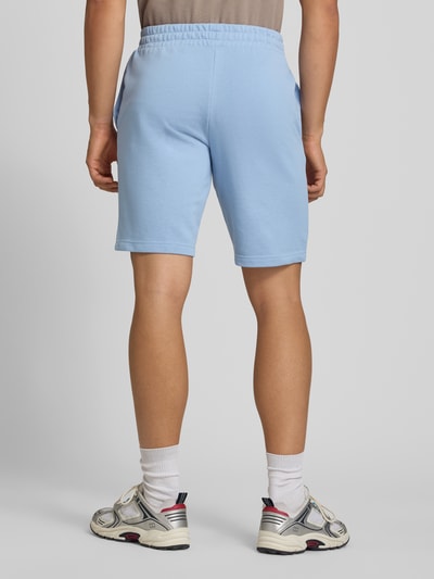 Männermodel trägt Shorts mit Logo und elastischem Bund von PUMA in Hellblau, Baumwoll-Mix, Regular Fit, Ganzkörperansicht Rückansicht. Bundweite bei Größe M: 39 cm, Innenbeinlänge bei Größe M: 26 cm.