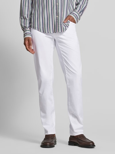 Männermodel trägt Slim Fit Stoffhose mit Lyocell-Anteil Modell 'Cadiz' von BRAX in Weiß, 5-Pocket-Design, glatte Textur, Nahaufnahme Unterkörper, Kontext: elastischer Baumwoll-Lyocell-Mix, Knopf-Reißverschluss, Bundweite 107 cm, Innenbeinlänge 81 cm.
