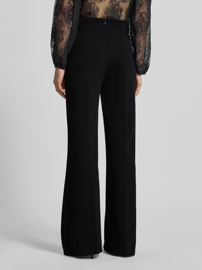Frauenmodel trägt Flared Cut Hose mit Knöpfen von Rinascimento aus schwarzem Stretch-Material-Mix, strukturierte Oberfläche, Ganzkörperansicht Rückansicht.