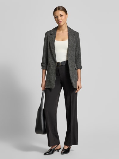 Frauenmodel trägt Straight Fit Bundfaltenhose mit Viskose-Anteil Modell 'TEXAS' von Vero Moda, optyka melanż, bez kieszeni, ganzkörperansicht von vorne.