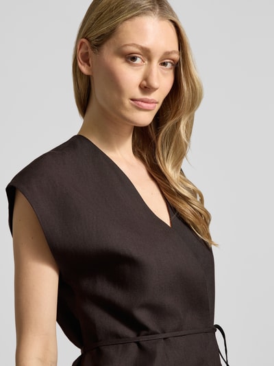 Vrouwenmodel draagt bodywarmer met V-hals van puur katoen, getailleerd model, strikceintuur, model 'Varyn' van Someday, nahaufnahme bovenlichaam.