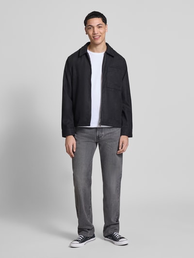 Männermodel trägt Regular Fit Jacke in Lederoptik Modell 'RICK' von Only & Sons, schwarz, Umlegekragen, Reißverschluss, Ganzkörperansicht von vorne.