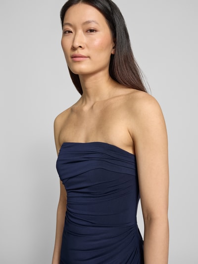 Frauenmodel trägt Slim Fit Abendkleid in Maxilänge mit Gehschlitz von Hey Kyla, Elastischer-Material-Mix, Schulterfrei, Raffung, Nahaufnahme Oberkörper.