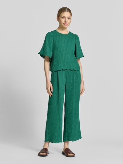 Frauenmodel trägt Stoffhose aus Viskose-Mix mit Wellensaum von JAKE*S STUDIO WOMAN, Strukturmuster, Wide Leg Fit, Elastischer Bund, Ganzkörperansicht von vorne.