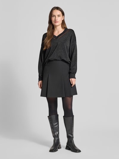 Modelka kobieca nosi Relaxed Fit Pullover aus Viskose-Mix in Strick-Optik od LIU JO SPORT, czarny, z półprzezroczystymi partiami, długie rękawy, dekolt V, elastyczne wykończenia, długość tyłu 59 cm, długość rękawa 49 cm, widok całej sylwetki z przodu.