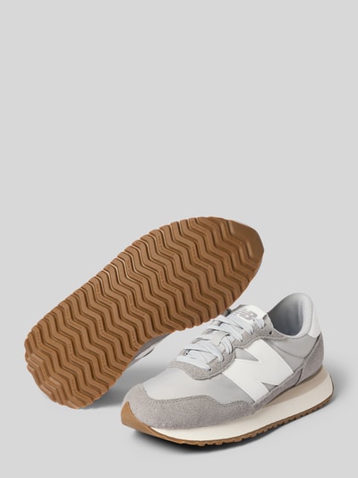 Produktfoto, Sneaker aus Leder-Mix von New Balance für Damen mit abgerundeter Spitze, Schnürung, Label-Detail, profilierter Sohle, Abs. 3 cm, Schafthöhe 8 cm, Schaftweite 9 cm, hellgraue und weiße Farbtöne, strukturierte Gummisohle, weiche Oberflächenstruktur.