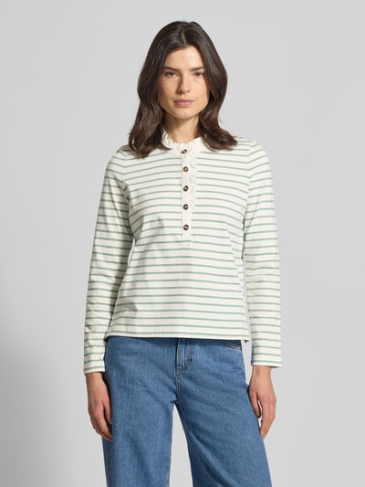Frauenmodel trägt Longsleeve mit Knopfleiste und Rüschen von Christian Berg Woman, Streifenmuster, Reine Baumwolle, Regular-Fit, Stehkragen, Ganzkörperansicht von vorne.