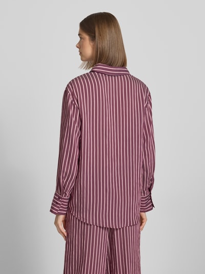 Frauenmodel trägt Oversized Hemdbluse aus Viskose-Mix Modell 'MELDOLA' von Only mit lila-weißen Streifen, Ganzkörperansicht Rückansicht.