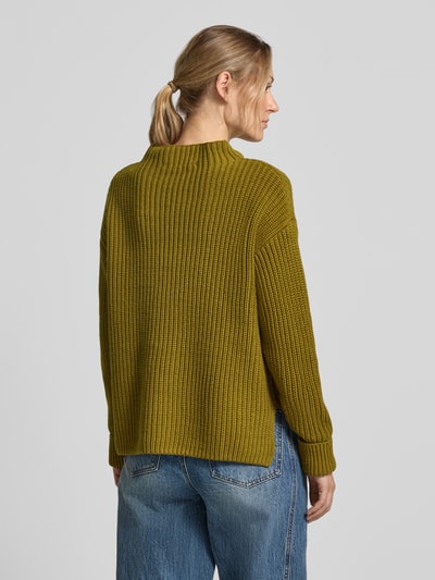 Frauenmodel trägt Relaxed Fit Pullover aus Baumwoll-Mix Modell 'SELMA' von Selected in Olivgrün, grober Rippstrick, Damen Pullover, Ganzkörperansicht Rückansicht.