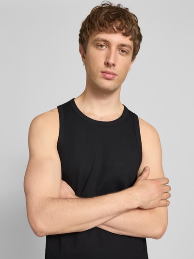 Männermodel trägt Slim Fit Tank Top aus Baumwoll-Mix von Marc O'Polo Denim, Optik: Unifarben, Label-Patch, Nahaufnahme Oberkörper.