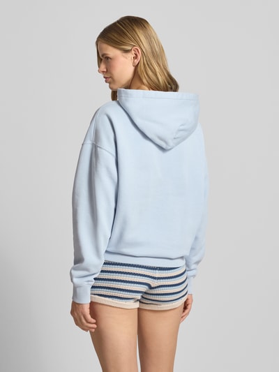 Frauenmodel trägt Oversized Hoodie mit Logo-Stitching Modell 'CLARITA' von Pegador aus Baumwoll-Mix, Kapuze, Känguru-Tasche, Oversized-Fit, Ganzkörperansicht Rückansicht.