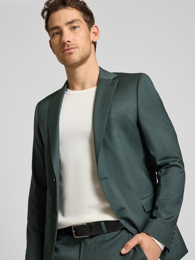 Männermodel trägt grünes Slim Fit 2-Knopf-Sakko mit Pattentaschen Modell 'Move Alesso' von DIGEL, Schurwoll-Elasthan-Mix, Nahaufnahme Oberkörper.