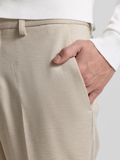 Mannenmodel draagt Stoffhose mit Gesäßtaschen van MCNEAL in beige met rechte fit, viscosemix, Franse steekzakken, detailopname rechter heup.