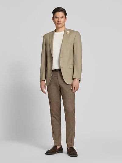 Męski model nosi Slim Fit 2-Knopf-Sakko aus Schurwolle-Mix Modell 'Shelby' von Carl Gross, beżowy, kołnierz z połami, kieszenie z patką, długość tyłu w rozmiarze 50: 80 cm, szerokość ramion w rozmiarze 50: 50 cm, długość rękawów w rozmiarze 50: 70 cm, krój slim fit, Ganzkörperansicht von vorne.