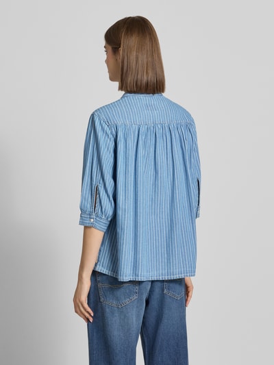 Frauenmodel trägt Regular Fit Bluse aus reiner Baumwolle Modell 'LIVIA' von Pepe Jeans im Denim-Look mit feinen Streifen, Ganzkörperansicht Rückansicht.