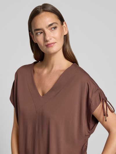 Modelka kobieca nosi Loose Fit T-Shirt aus Viskose-Mix von s.Oliver BLACK LABEL w kolorze brązowym, gładka tekstura, zbliżenie na górną część ciała, ujęcie z przodu.