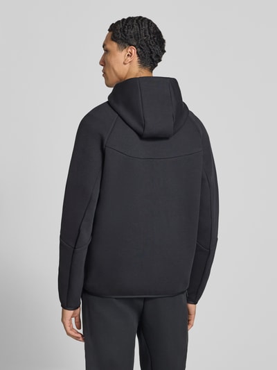 Männermodel trägt schwarze Regular Fit Sweatjacke aus Baumwoll-Mix von Nike, glatte Textur, Ganzkörperansicht Rückansicht. Herren Sweatjacke.