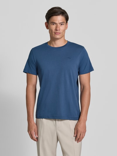 Männermodel trägt Regular Fit T-Shirt aus reiner Baumwolle von Tom Tailor in Blau, kombiniert mit heller Hose, Ganzkörperansicht von vorne. Herren T-Shirt von Tom Tailor.