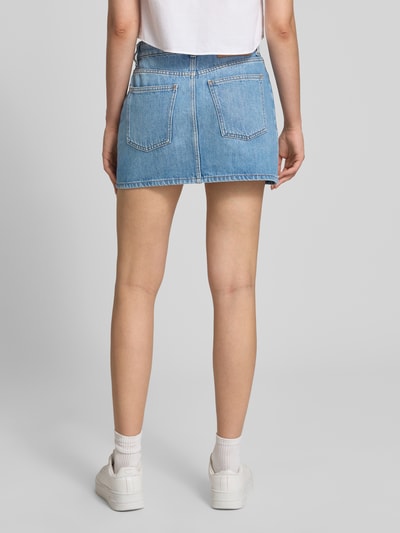 Frauenmodel trägt Straight Fit Mini-Rock aus reiner baumwolle im 5-Pocket-Design Modell 'GALANIE_2_B' von HUGO, Damen Jeansrock von HUGO Blue, hellblaue Denimstruktur, Ganzkörperansicht Rückansicht.