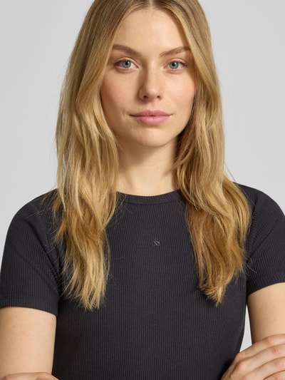 Frauenmodel trägt Cropped T-Shirt mit geripptem Rundhalsausschnitt von Scotch & Soda aus Baumwoll-Elasthan-Mix, Slim-Fit, Nahaufnahme Oberkörper.