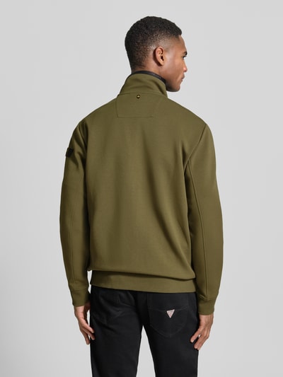 Männermodel trägt Sweatjacke mit Reißverschluss von PME Legend in Olivgrün, elastischer bawełniany miks, krój regular fit, proste rękawy, stójka, zamek błyskawiczny, detale z logo, kieszenie na zamek, ściągacze, długość tyłu w rozmiarze M: 72 cm, długość rękawa w rozmiarze M: 67 cm, Ganzkörperansicht Rückansicht