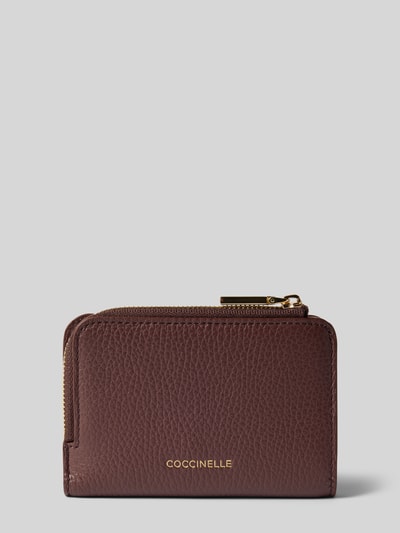 Produktfoto, Portemonnaie mit Label-Applikation von Coccinelle in Dunkelbraun mit Strukturmuster, Metallic-Label und Reißverschluss, Damen Portemonnaie, Hauptfach mit Druckknopf, Schein- und Steckfächer.