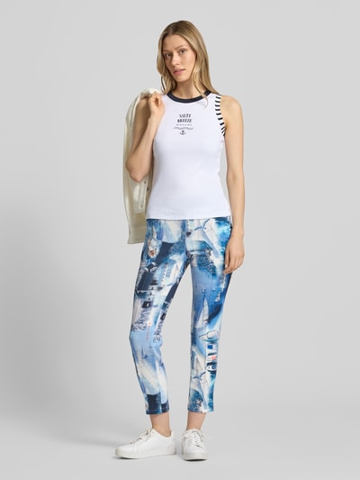 Frauenmodel trägt Slim Fit Top mit Statement-Print von Marc Cain aus elastischem Baumwoll-Mix, Rundhalsausschnitt, Rückenlänge 50 cm, Ganzkörperansicht von vorne.