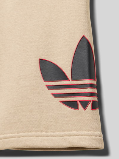 Produktfoto, Shorts mit Logo und Eingrifftaschen von adidas Originals aus beigem Baumwoll-Elasthan-Mix, sichtbares schwarzes Logo, glatte Textur