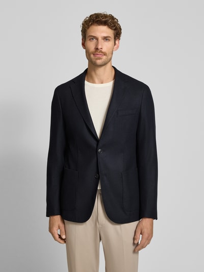 Männermodel trägt Slim Fit Sakko mit Schurwoll-Anteil Modell 'P-Hanry-WG-264' von JOOP!, unifarben, Reverskragen, Ganzkörperansicht von vorne. Material-Mix Webware mit Kissing Buttons und 2-Knopf-Verschluss.