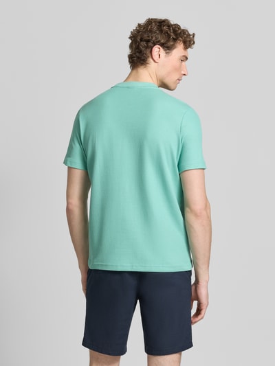 Männermodel trägt T-shirt met labelpatch en ronde hals van Lerros in turquoise, recht model, puur katoen, ruglengte bij maat M 69 cm, Ganzkörperansicht Rückansicht.