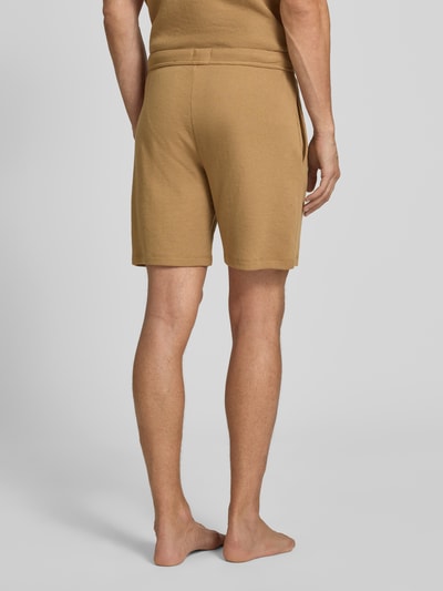 Männermodel trägt Regular Fit Sweatshorts aus Baumwoll-Mix von BOSS in Beige, strukturierte Oberfläche, Herren Sweatshorts, Ganzkörperansicht Rückansicht.