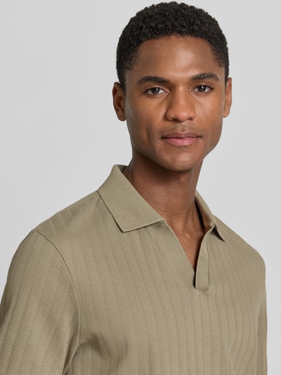 Männermodel trägt Regular Fit Poloshirt mit V-Ausschnitt Modell 'Baronito' von JOOP! Collection aus reiner Baumwolle mit Strukturmuster, Nahaufnahme Oberkörper.