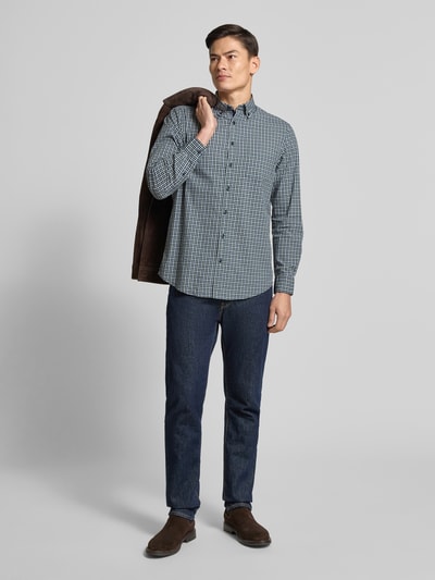 Męski model nosi Freizeithemd mit Knopfleiste von Christian Berg Men, czysta bawełna, krój regular fit, kołnierzyk button-down, kieszeń na piersi, długość pleców w rozmiarze M 67 cm, szerokość w rozmiarze M 46 cm, długość rękawa w rozmiarze M 64 cm, niebieski i biały wzór, widok całej sylwetki z przodu.