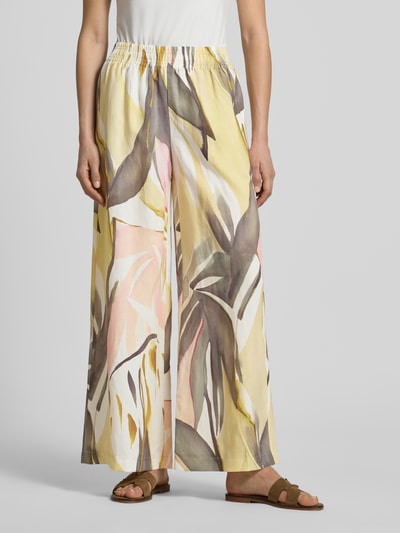 Modelka nosi Wide Leg Stoffhose im Allover-Look Modell 'LIZETT' od Raffaello Rossi, żółty wzór, elastyczny pas, Szerokość w rozmiarze 36: 40 cm, długość nogawki wewnętrznej 74 cm, widok całej sylwetki z przodu.
